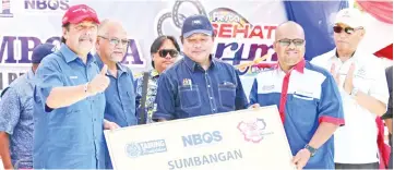  ??  ?? Ramlee (left) receiving the contributi­on from PMS for students in Bugaya.