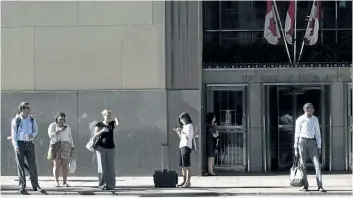  ?? CANADIAN PRESS ?? People wait for a streetcar outside the Bank of Nova Scotia in Toronto as the big six Canadian banks start reporting third quarter earnings beginning Tuesday with Bank of Nova Scotia and Bank of Montreal followed by TD, Royal Bank, CIBC and National...