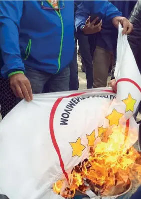  ??  ?? Le fiamme La bandiera del Movimento bruciata da alcuni cittadini durante la protesta contro i Cinque Stelle per il via libera del governo alla costruzion­e del gasdotto Tap (Ansa)