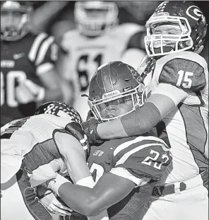  ?? Special to the Democrat-Gazette/JIMMY JONES ?? Greenwood linebacker Travis Cox (15) and a teammate tackle Benton running back Zak Wallace (23) during the Bulldogs’ 33-17 victory over the Panthers on Friday in Benton. For more high school football photos, visit arkansason­line.com/galleries.