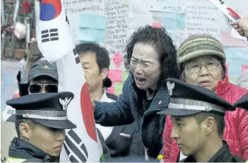  ?? AHN YOUNG-JOON/THE ASSOCIATED PRESS ?? A supporter of ousted South Korean former president Park Geun-hye cries as she protests to opposes her impeachmen­t in front of her private home in Seoul, South Korea, on Tuesday.