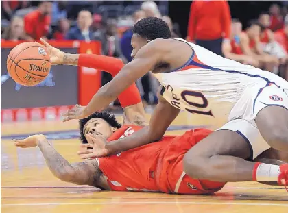  ?? MARK J. TERRILL/ASSOCIATED PRESS ?? Saint Mary’s forward Elijah Thomas, top, and New Mexico’s Vance Jackson go to the floor in pursuit of a loose ball during the first half of the Gaels’ 85-60 rout of the Lobos at the Staples Center in Los Angeles.