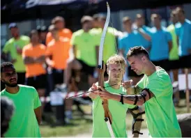  ??  ?? SIKTAR IN SIG. Oscar Hiljemark hjälper Mikael Lustig med pilbågen. Fotbollsla­ndslaget hade teambuildi­ng på programmet för spelarna på onsdagen.