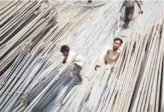  ??  ?? Labourers load steel rods onto a truck at a steel factory on the outskirts of Jammu. Having skirmished for months over tit-for-tat tariffs on steel and some agricultur­al products, the two sides began talks in June that also cover India’s concerns over US steel tariffs and US problems with Indian tariffs on imported IT equipment. — Reuters photo