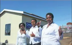  ?? PROVIDED TO CHINA DAILY ?? Local residents pose in front of the sample house built by CMIG Drawin.