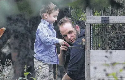  ?? CP PHOTO ?? Joshua Boyle and his son Jonah play in the garden at the home of his parents in Smiths Falls, Ont., on Saturday. Boyle, who along with his wife Caitlan Coleman were held hostage for five years by a Taliban-linked network and forced to raise three...