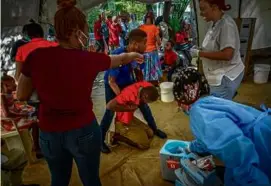  ?? RAMON ESPINOSA/ASSOCIATED PRESS ?? A young man suffering from cholera symptoms was helped at a Doctors Without Borders clinic in Port-au-Prince.