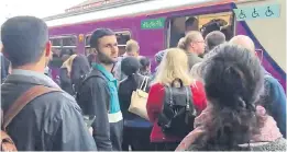  ??  ?? Frustrated passengers in Bolton are unable to board a Manchester train which arrived 25 minutes late yesterday while another service was cancelled