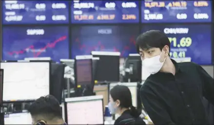  ??  ?? A currency trader watches monitors at the foreign exchange dealing room of the KEB Hana Bank headquarte­rs in Seoul, South Korea, April 5, 2021. Asian stock markets were mostly higher Monday after Wall Street hit a record high on optimism the spread of coronaviru­s vaccines might allow global business to return to normal. (AP)