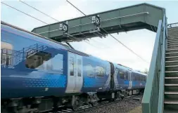  ?? RICARDO ?? A Class 385 electric multiple unit travels through one of the scanning points on a footbridge at Braidwood.