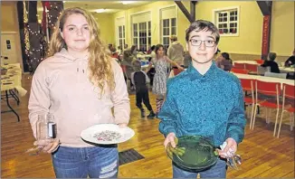  ?? IAN FAIRCLOUGH/SALTWIRE NETWORK ?? Anna Morse and Jacob Hirtle hold utensils and dishes they brought to Western Kings 4-H dinner Friday night. The club asks members to bring their own tableware to events involving food as a way to cut down on disposable items going into the waste stream.