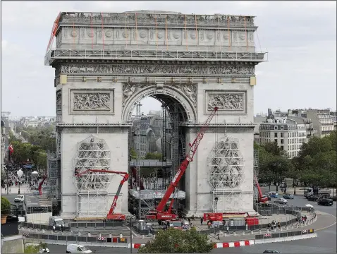  ?? (AP/Adrienne Surprenant) ?? Cranes are installed Aug. 24 at the Arc de Triomphe in Paris as workers prepare the famed Paris monument for the project called “L’Arc de Triomphe, Wrapped” by late artist Christo who wished this project to be continued after his death. The Arc de Triomphe will be covered with fabric in silvery blue, and of red rope of the same fabric.