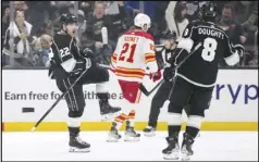  ?? Associated Press ?? Kings left wing Kevin Fiala (left) celebrates his goal with defenseman Drew Doughty (right) as Calgary Flames center Kevin Rooney skates away on Thursday in Los Angeles.