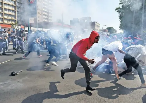  ??  ?? Mayhem erupted when police dispersed a group of protesting #FeesMustFa­ll students with stun grenades and rubber bullets after they crossed a barrier at an entrance to Wits University in Braamfonte­in.