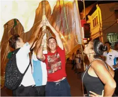  ??  ?? Having a go at it: Goubet trying to balance a flagpole on his shoulder while Hammouti watches at the parade.