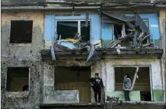  ?? EVGENIY MALOLETKA — THE ASSOCIATED PRESS ?? Local residents stand on the balconies of their apartments damaged by Russian shelling in Dobropilly­a, Donetsk region, eastern Ukraine, Saturday, April 30.