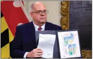  ?? (AP/Brian Witte) ?? Maryland Gov. Larry Hogan shows a copy of a congressio­nal map approved by the General Assembly that is crossed out in red as he announces his veto of the plan during a Dec. 9 news conference in Annapolis, Md. The Legislatur­e overrode his veto the same day he issued it.