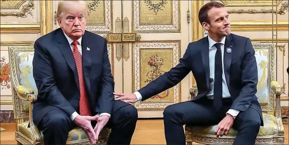  ??  ?? TOUCHY: President Macron tries to ease the tension by reaching out to pat Mr Trump’s thigh, but the US leader looks distinctly unimpresse­d by the gesture