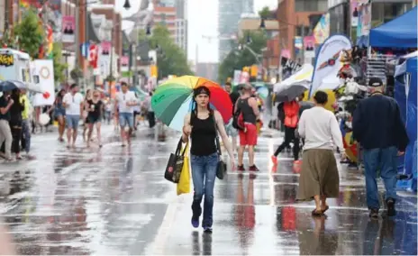  ?? BERNARD WEIL/TORONTO STAR PHOTOS ?? Many in the roaring, rainbow-clad crowd came out and cheered as each float went by, despite a brief downpour before the march began.