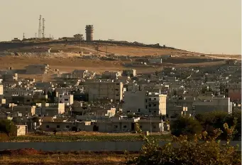  ?? AP ?? In this photo taken from the Turkish side of the border between Turkey and Syria, a US forces outpost is seen on a hilltop outside Kobani, Syria. The outpost was bracketed by artillery fire at the weekend.