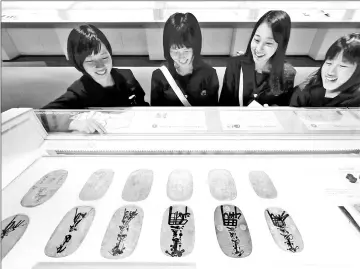  ??  ?? Visitors look at various oban gold coins used during the Edo period. The gold content varies by era. — Photos by Taku Yaginuma for The Yomiuri Shimbun