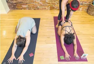  ?? TIJANA MARTIN/THE CANADIAN PRESS ?? Staff members from Yogaspace, left to right, Emily Sitter, Zeena Dotiwalla and Lauren Messervey demonstrat­e how their consent cards are used in their yoga studio in Toronto.