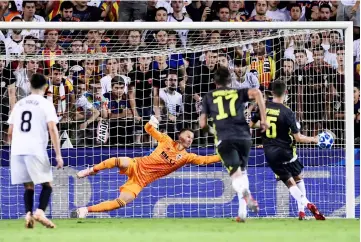  ??  ?? Juventus’ defender Miralem Pjanic (right) scores against Valencia’s goalkeeper Neto during the UEFA Champions League group H match at the Mestalla stadium in Valencia. — AFP photo