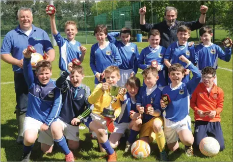  ??  ?? Managers Robbie Byrne and Bernard Burke and the Dromin team celebratin­g winning the U-11 Group 2 Cup in Dundalk.