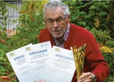  ?? Foto: Alois Thoma ?? BLSV‰Kreisvorsi­tzender Fritz Birkner präsentier­t Pokal und Urkunden, mit denen die eifrigsten Sportabzei­chenerwerb­er ausgezeich­net werden.