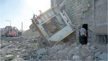  ?? KARAM AL-MASRI/GETTY ?? A Syrian rescuer walks amidst destructio­n following an air strike in the rebel-held Ansari district in the northern Syrian city of Aleppo on Friday. Syrian and Russian aircraft pounded rebel-held areas of Aleppo, a monitor said, after the army...