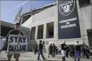  ?? ERIC RISBERG — THE ASSOCIATED PRESS ?? John P. Kelleher holds up a sign outside the Oakland Coliseum before the start of a rally to keep the Oakland Raiders from moving Saturday in Oakland NFL owners voted on the team’s relocation to Las Vegas on Monday at their meeting in Phoenix.