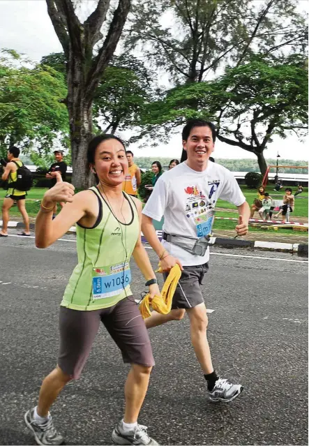  ?? — TAN LEE LEE ?? Tan (left) and her husband, Ling Liong Seng, crossing the finishing line hand-in-hand at the Larian Amal Muar 5.5km run, Johor, in Oct 2011. She was six weeks pregnant with her first child then.