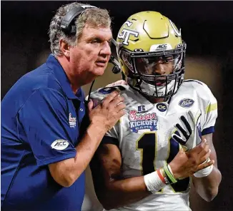  ?? HYOSUB SHIN / HSHIN@AJC.COM ?? Georgia Tech quarterbac­k TaQuon Marshall, chatting with coach Paul Johnson, rushed 44 times for 249 yards and five touchdowns in Monday’s double-overtime loss to Tennessee.