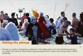  ?? AP ?? People in a variety of disguises celebrate in the frigid waters of Lake Orankesee during a so-called ‘Ice Carnival’ event featuring participan­ts from winter swimming clubs in Berlin yesterday.