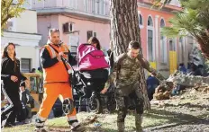  ?? Reuters ?? Men carry a stroller with a baby following a landslide on the Italian holiday island of Ischia, Italy, yesterday.