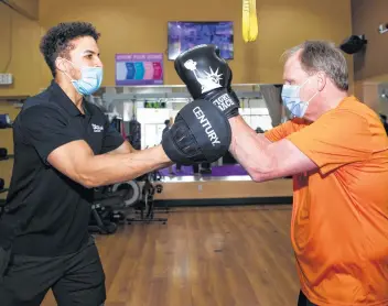  ?? Photos by Yi-Chin Lee / Staff photograph­er ?? Trainer Armin Smith, left, says Parkinson’s patients like Anthony Purser are tracked with a heart rate monitor during Rock Steady classes to ensure they’re not overexerci­sing.