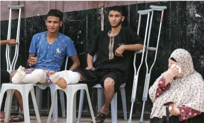  ?? — AFP ?? Wounded Palestinia­n men attend the funeral of Moein Al Saai, who died of wounds he sustained protesting at the Israeli-Gaza border, during his funeral in Gaza city on Saturday.