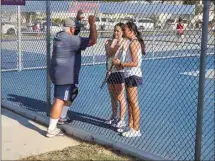  ?? CLAY CUNNINGHAM/THE CALIFORNIA­N ?? Liberty tennis coach Chris Campoy talks with Janelle Cruz and Kailani Lua during their No. 1 doubles match against Centennial on Wednesday. The Patriots improved to 6-0 and have yet to drop a set.