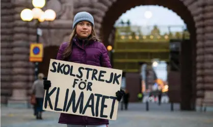  ?? Photograph: Jonathan Nackstrand/AFP/Getty Images ?? Greta Thunberg poses for a photo with a sign reading ‘School strike for climate’ as she protests in front of the Swedish parliament in November.