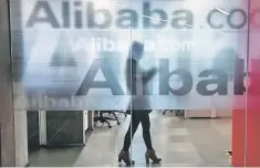  ??  ?? An employee is seen behind a glass wall with the logo of Alibaba at the company’s headquarte­rs on the outskirts of Hangzhou, Zhejiang province. Alibaba said on Monday it would take a major stake in one of China’s top food sellers for US$2.9 billion as...