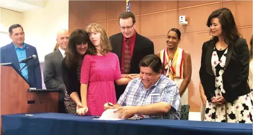  ?? MAUREEN SURIN ?? Ashley Surin stands with her parents Monday as Gov. J.B. Pritzker signs legislatio­n bolstering considerat­ions for schoolchil­dren who use medical cannabis.