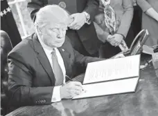  ?? PABLO MARTINEZ MONSIVAIS, AP ?? President Trump signs an executive order last Friday to review the 2010 Dodd-Frank financial oversight law. Last year, Rep. Jeb Hensarling introduced a plan to remove some of its rules.