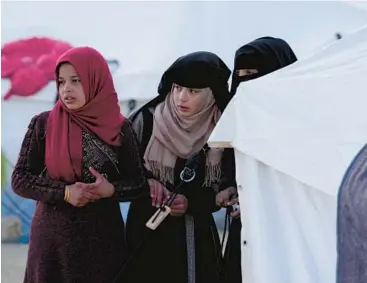  ?? HUSSEIN MALLA/AP ?? Girls who lost their homes in the earthquake watch for an aid distributi­on Sunday at a camp in Killi, Syria.