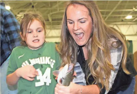  ?? PAUL A. SMITH ?? Bobbi Schmeling of Brookfield attempts to hold a brook trout caught by her daughter Allie.