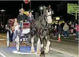  ??  ?? RIGHT: A horse and buggy travels down Main Street during Norman’s Christmas Parade.