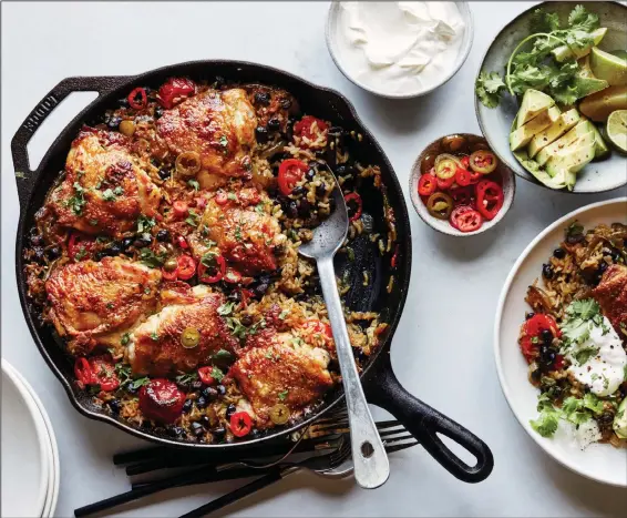  ?? (The New York Times/Con Poulos) ?? One-Pot Chicken Thighs With Black Beans, Rice and Chiles