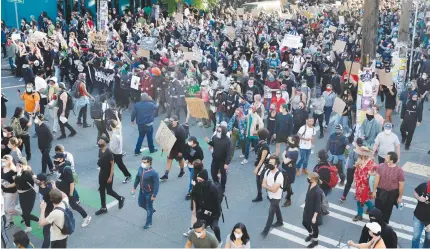  ?? AFP PHOTO ?? People march in protest of the death of George Floyd in the Capitol Hill neighborho­od of Seattle, Washington on June 1, 2020. Major US cities — convulsed by protests, clashes with police and looting since the death in Minneapoli­s police custody of George Floyd a week ago — braced for another day of unrest. More than 40 cities have imposed curfews after consecutiv­e nights of tension that included looting and the trashing of parked cars.