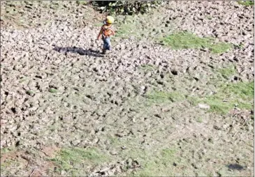  ?? HENG CHIVOAN ?? A boy walks across dried out fields near Khum Koh Chivaing school in Siem Reap province.