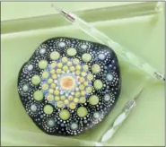  ?? AP PHOTO/HOLLY RAMER ?? This Oct. 14, 2018 photo shows a colorfully-painted mandala stone in Hopkinton, N.H. This version was painted using acrylic rods and dotting tools made specifical­ly for such painting. The stones can serve as pretty paperweigh­ts or decorative accents around the home.