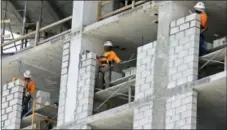  ?? THE ASSOCIATED PRESS ?? Constructi­on workers work on an apartment high rise in Miami.